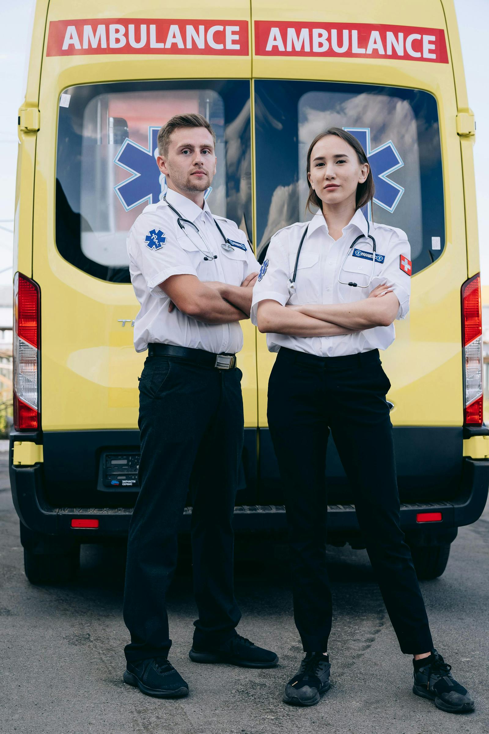 Two uniformed responders staged in front of an ambulance during coordinated operations training.